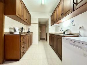 a kitchen with wooden cabinets and a white appliance at Santa Luzia Resident sea view in Funchal