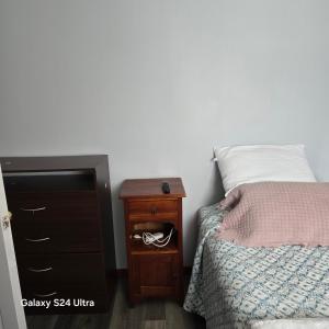 ein Schlafzimmer mit einem Bett und einem hölzernen Nachttisch mit einem Bett sidx sidx sidx in der Unterkunft Casa en Frutillar in Frutillar + 5 Fotos
