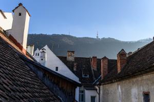 a view of roofs of buildings with mountains in the background at Republicii Residence in Braşov