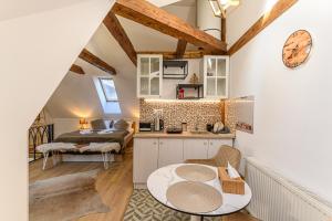 a kitchen and living room with a table in a room at Republicii Residence in Braşov