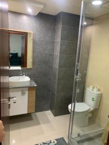 een badkamer met een toilet, een wastafel en een douche bij Apartment in a residence with pool in Mohammedia +12 foto's