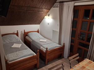 twee bedden in een kleine kamer met een raam bij Vagabund Vendégház in Etyek