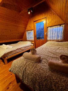 una camera con due letti in una baita di legno di Świerkowa Chata a Targanice