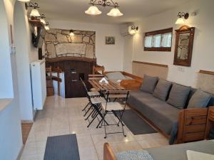 een woonkamer met een bank, een tafel en stoelen bij Vagabund Vendégház in Etyek