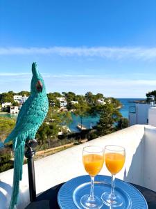 a bird sitting on a table with two glasses of wine at Chalet Barceló Rocher in Cala d´Or