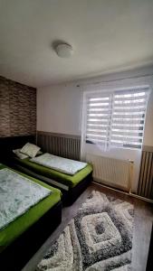 een slaapkamer met 2 bedden, een raam en een tapijt bij ANTONIA Central Apartament in Tîrnăveni