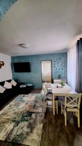 een woonkamer met een tafel, stoelen en een bank bij ANTONIA Central Apartament in Tîrnăveni