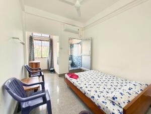 a bedroom with a bed and two chairs in it at Premium AC Rooms at Taj Heritage Hotel and Restatrant in Jorhat +1 photo