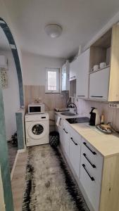 een keuken met witte kasten en een kookplaat oven bij ANTONIA Central Apartament in Tîrnăveni