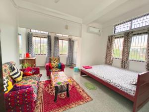 a living room with two beds and a couch at Premium AC Rooms at Taj Heritage Hotel and Restatrant in Jorhat