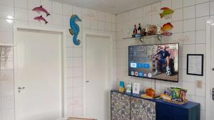 La salle de bains est pourvue d'une télévision sur un mur carrelé. dans l'établissement Próximo das 42 Praias, à Florianópolis