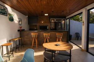 a patio with a table and chairs and a kitchen at Casa Faya Foz in Foz do Iguaçu