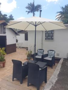 a patio with a table and chairs and an umbrella at case creole in Saint-Joseph