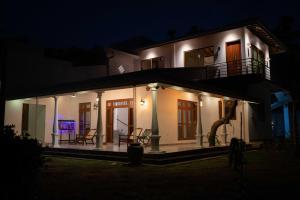 a house lit up at night with chairs at Villa Paddy Breeze in Galle
