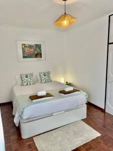 een witte slaapkamer met een bed in een kamer bij City center Loreto in Ponta Delgada