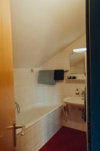 a bathroom with a bath tub and a sink at Haus am Weiher in Schwangau