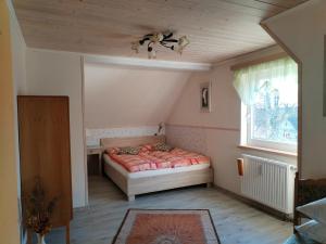 een kleine slaapkamer met een bed en een raam bij Chaloupka u Rity in Bublava