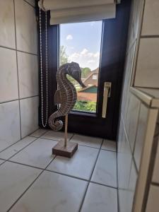 a statue of a snake in a bathroom window at Ferienwohnung Thomée in Looft