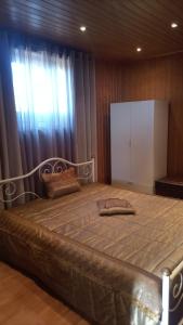 ein großes Bett in einem Zimmer mit Fenster in der Unterkunft Casa Rosàlia in Castro Daire