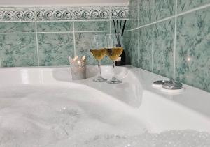 two glasses of wine sitting on a bath tub at Sielskie Sitno in Sitno +80 photos