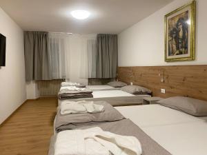 eine Gruppe von 4 Betten in einem Zimmer in der Unterkunft Dolomiti Lodge - Fit & Well in Belluno