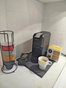 een koffiezetapparaat en een kopje koffie op een aanrecht bij CityPark BnB in Pristina