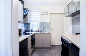 a kitchen with a sink and a counter top at Cosy Luxe Manchester Home With Fresh Bakes in Manchester