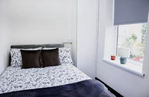 a white bedroom with a bed and a window at Cosy Luxe Manchester Home With Fresh Bakes in Manchester