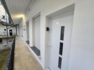 een gang met witte muren en een witte deur bij 5G-Studio tout équipé avec chambre proche Paris in Issy-les-Moulineaux