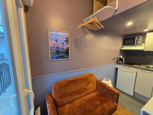 een bruine stoel in een keuken met een magnetron bij 5G-Studio tout équipé avec chambre proche Paris in Issy-les-Moulineaux +3 foto's