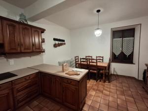 una cucina con mobili in legno, tavolo e sedie di Gite ''Le Coulhou'' - Ariège a Ferrières-sur-Ariège Altre 20 foto