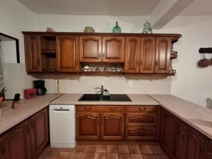una cucina con mobili in legno e un lavello di Gite ''Le Coulhou'' - Ariège a Ferrières-sur-Ariège