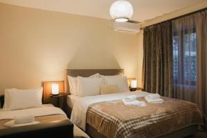 une chambre d'hôtel avec deux lits avec des serviettes dessus dans l'établissement The Callistone House, à Mesochórion