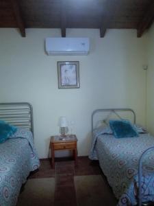 a bedroom with two beds and a table with a lamp at Casa Rural Cho Agustin in Erjos-El Tanque