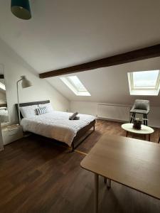 une chambre avec un lit et une table et deux fenêtres dans l'établissement 63 Spellow Lane, à Liverpool