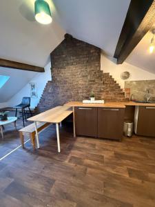 une cuisine avec une table en bois et un mur en briques dans l'établissement 63 Spellow Lane, à Liverpool