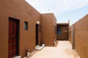 an alley between two brown buildings with a fire hydrant at Tasha Coastal Accommodation in Walvis Bay