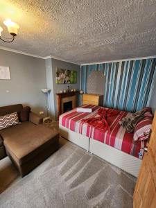 een slaapkamer met een bed en een bank erin bij The Rushdon in Grays Thurrock