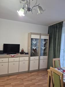 ein Wohnzimmer mit einem Flachbild-TV auf einer Kommode in der Unterkunft Apartament Lidka Zaprasza in Kwidzyn