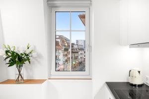 a kitchen with a window and a vase of flowers at La Suite du Bourg in La Tour-de-Peilz +31 photos