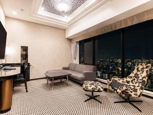 een woonkamer met een bank, een stoel en een bureau bij APA Hotel & Resort Osaka Umeda Eki Tower in Osaka