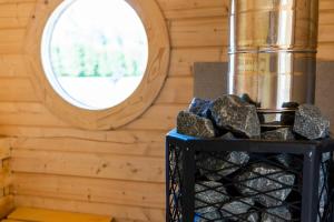 ein Zimmer mit einem Ofen und einem runden Fenster in der Unterkunft Cope un Pirts in Yumprava