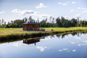 ein Gebäude neben einem See mit einem Picknicktisch in der Unterkunft Cope un Pirts in Yumprava