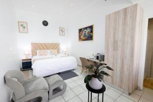 a white bedroom with a bed and a table and chairs at Riveria Guest Lodge and SPA in East London +45 photos