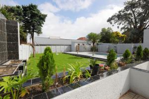 a garden with trees and plants on a fence at Riveria Guest Lodge and SPA in East London