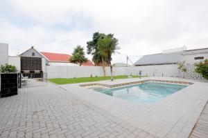a swimming pool in a yard next to a building at Riveria Guest Lodge and SPA in East London