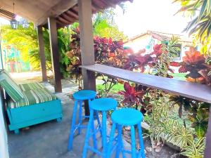 een tafel en twee blauwe krukjes onder een veranda bij De Boa na Lagoa Cabo Frio in Cabo Frio