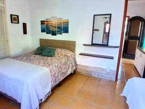 een slaapkamer met een bed en een spiegel aan de muur bij De Boa na Lagoa Cabo Frio in Cabo Frio