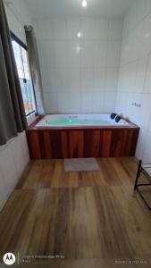 una vasca da bagno in una camera con pavimento in legno di Oasis na montanha a Bueno Brandão