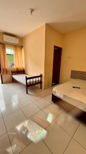 een lege kamer met 2 bedden en een raam bij Suítes litoral in Caraguatatuba +7 foto's